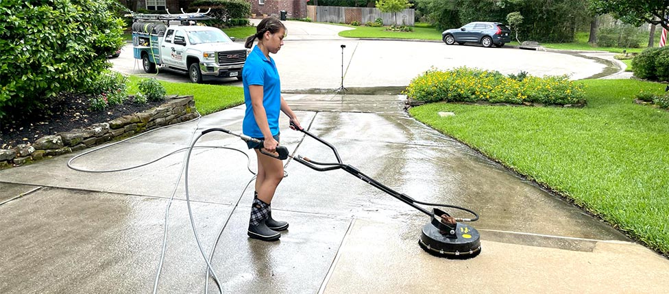 Crew member cleaning a driveway.
